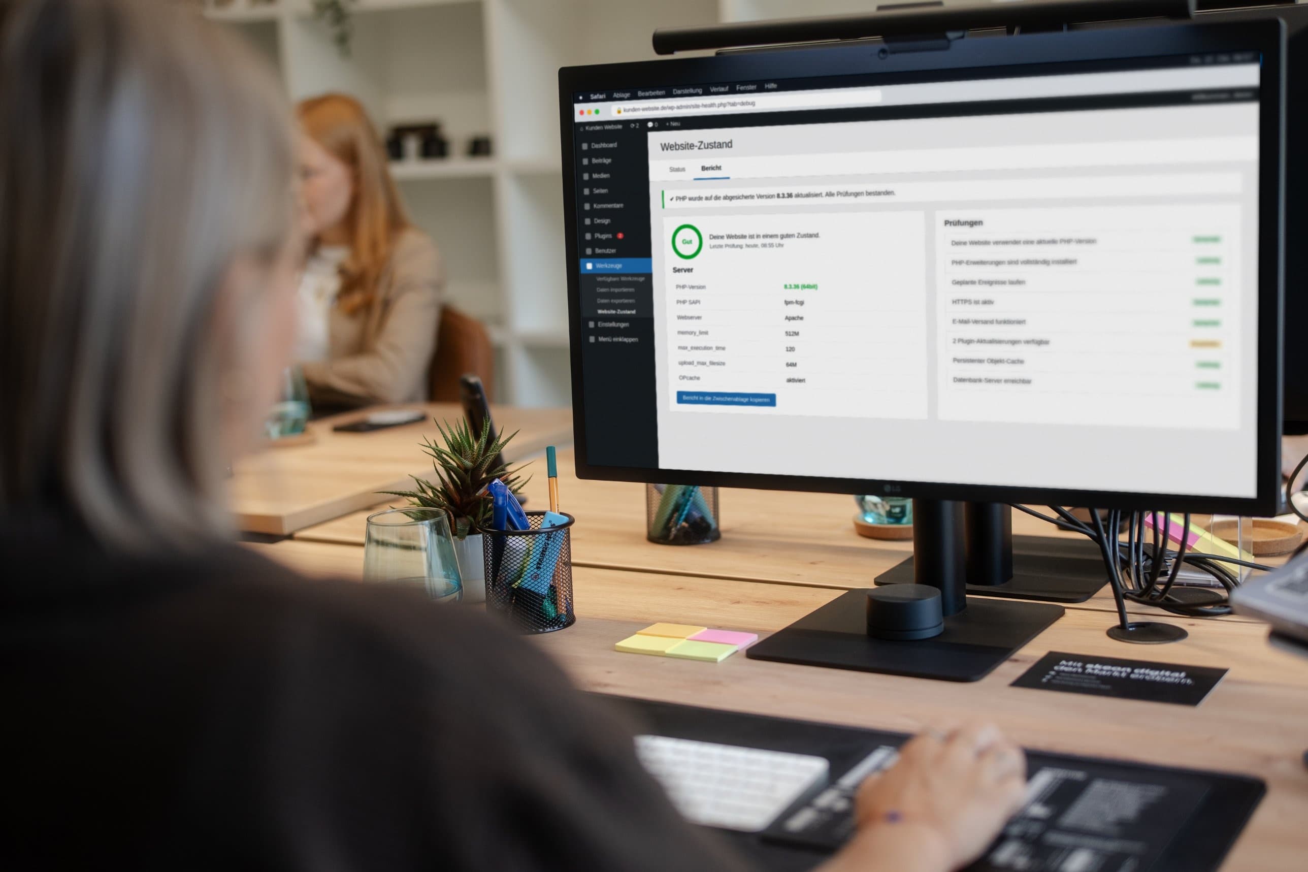 Person am Schreibtisch prüft im WordPress-Menü „Website-Zustand“ die PHP-Version