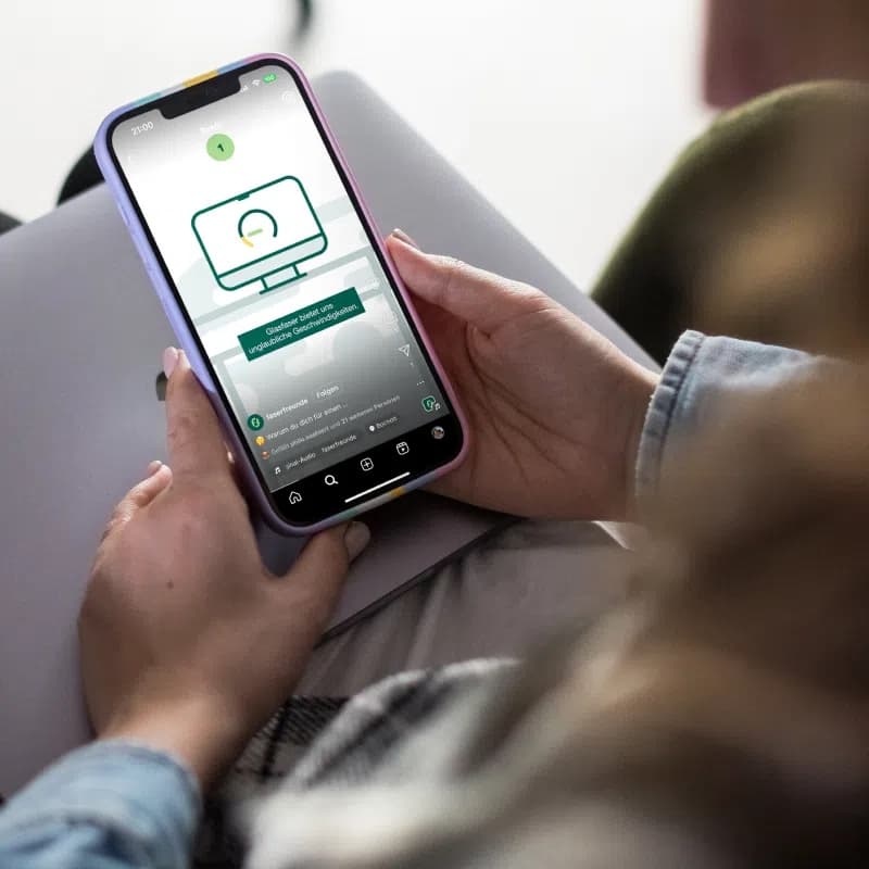 Hand hält ein Smartphone mit der faserfreunde-Website