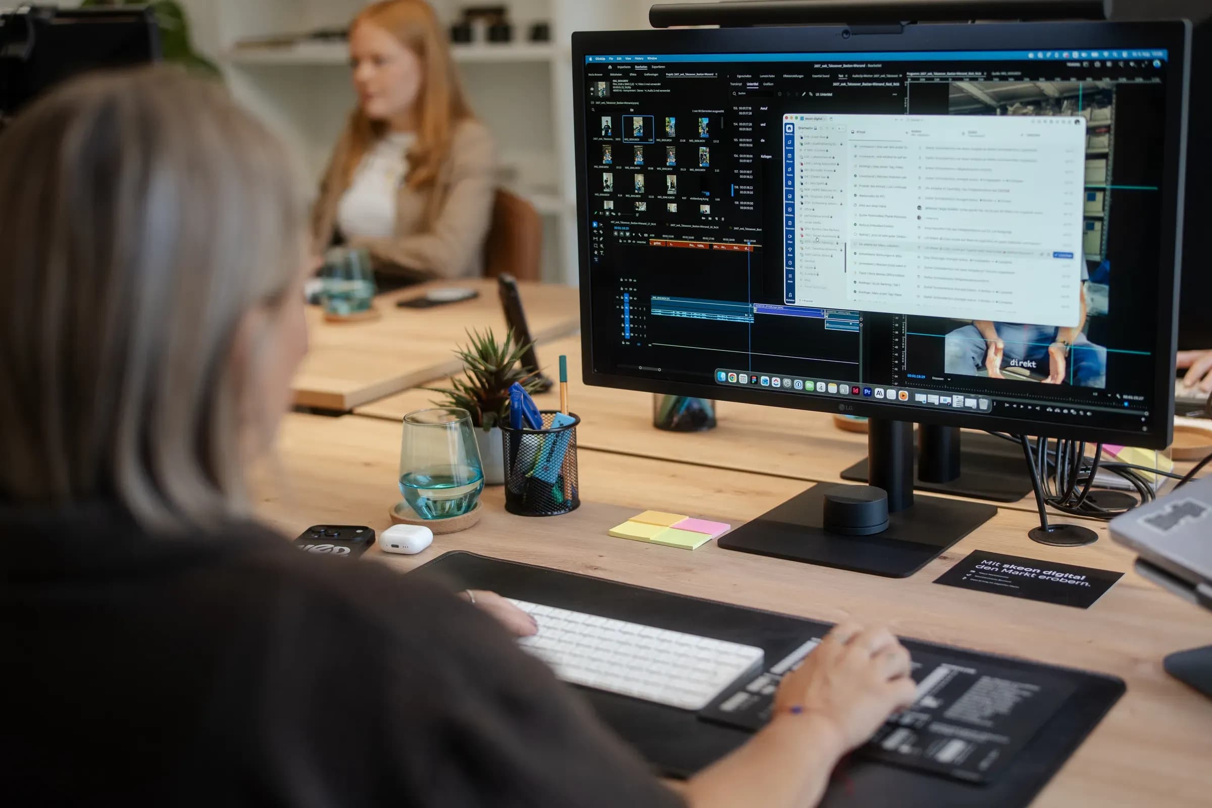 Monitor mit einer Auswertung von KI-Antworten, im Hintergrund zwei Kolleginnen von skeon digital