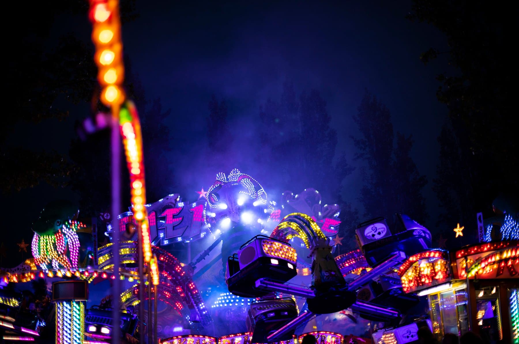 Leuchtende Fahrgeschäfte der Bocholter Kirmes bei Nacht