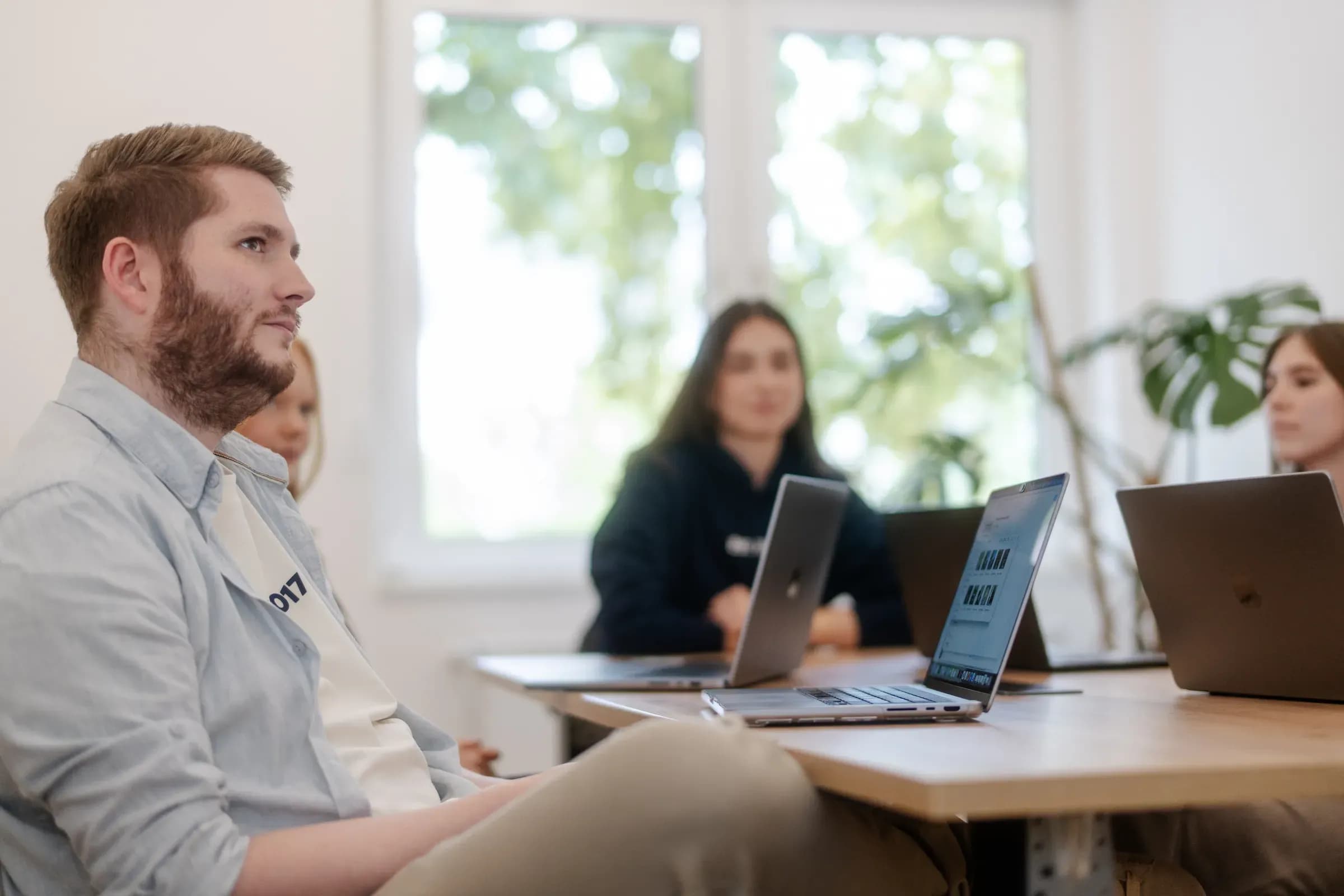 Teammitglieder von skeon digital an Laptops im Besprechungsraum