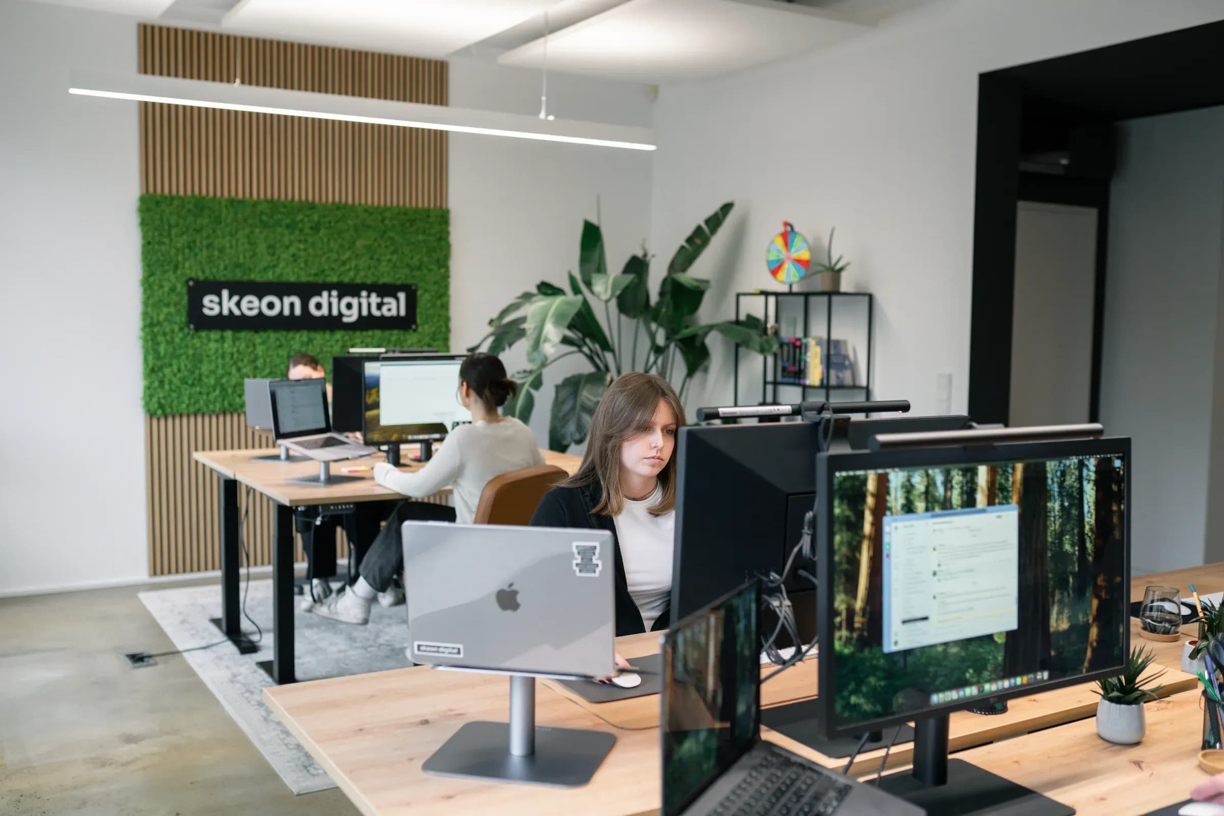 Blick in das Büro von skeon digital mit Mooswand, Arbeitsplätzen und Team