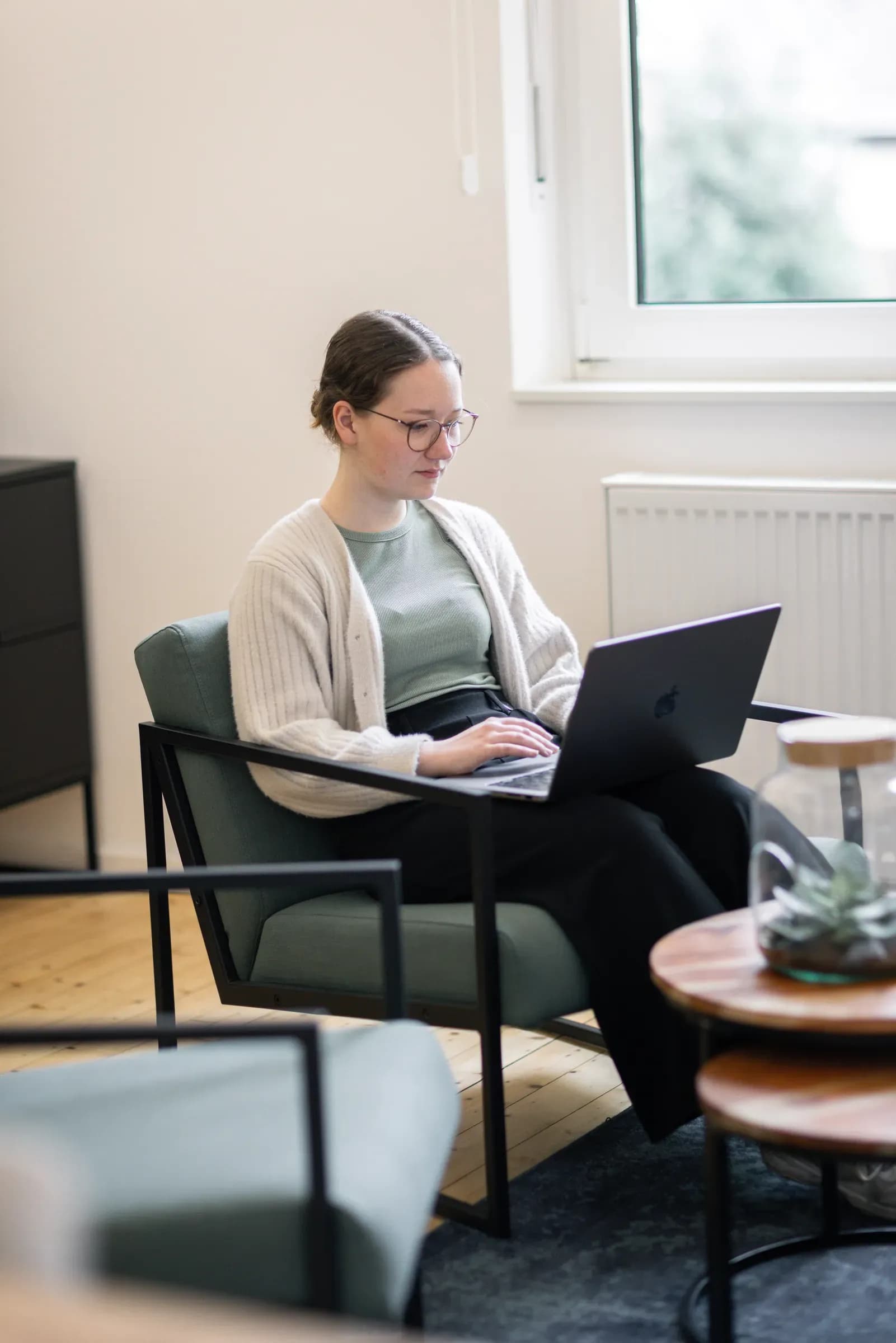 Kollegin von skeon digital arbeitet mit dem Laptop im Sessel