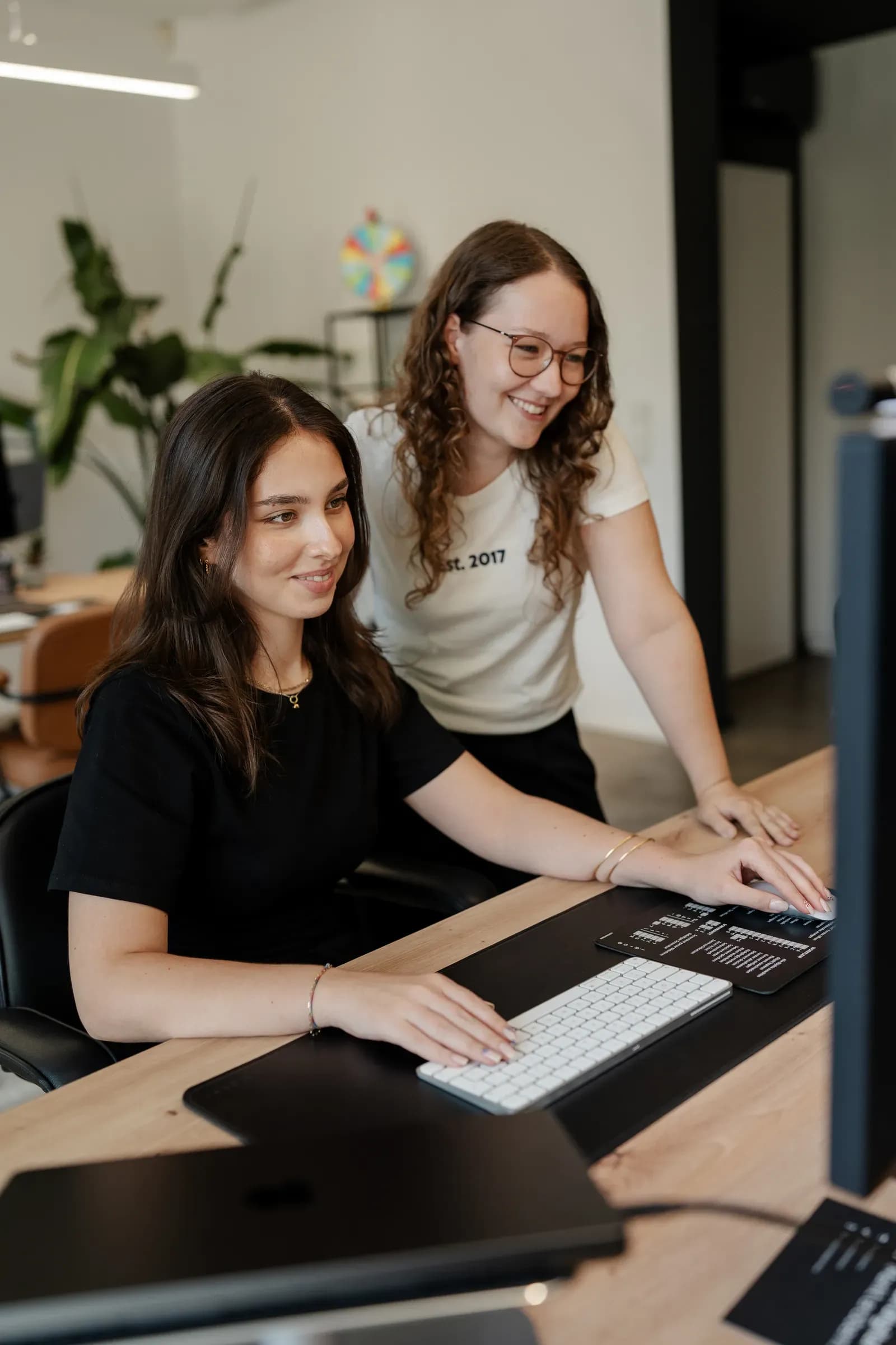 Zwei Kolleginnen von skeon digital schauen gemeinsam auf Auswertungen am Monitor
