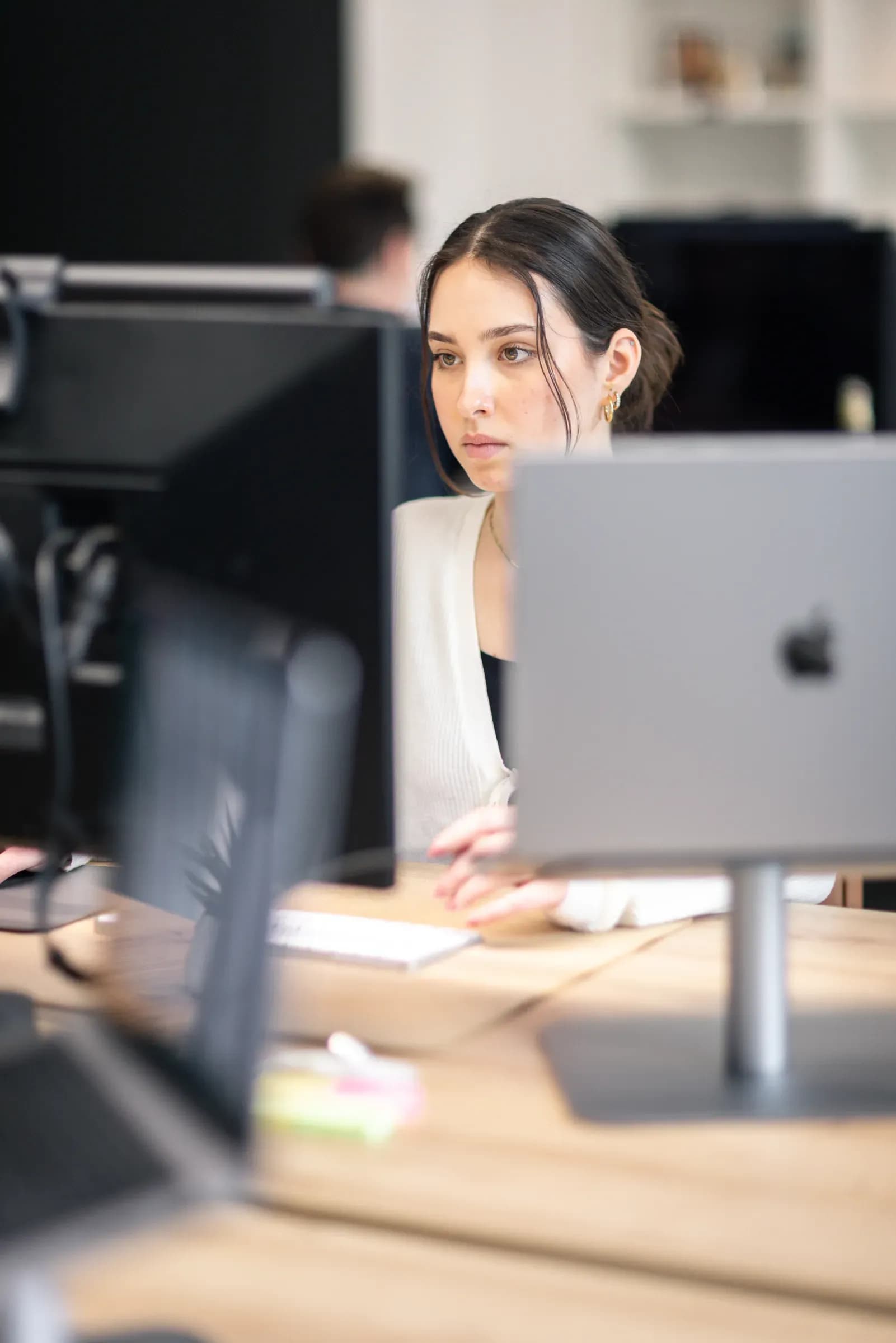 Kollegin von skeon digital am Monitor, im Vordergrund der Rand eines Bildschirms