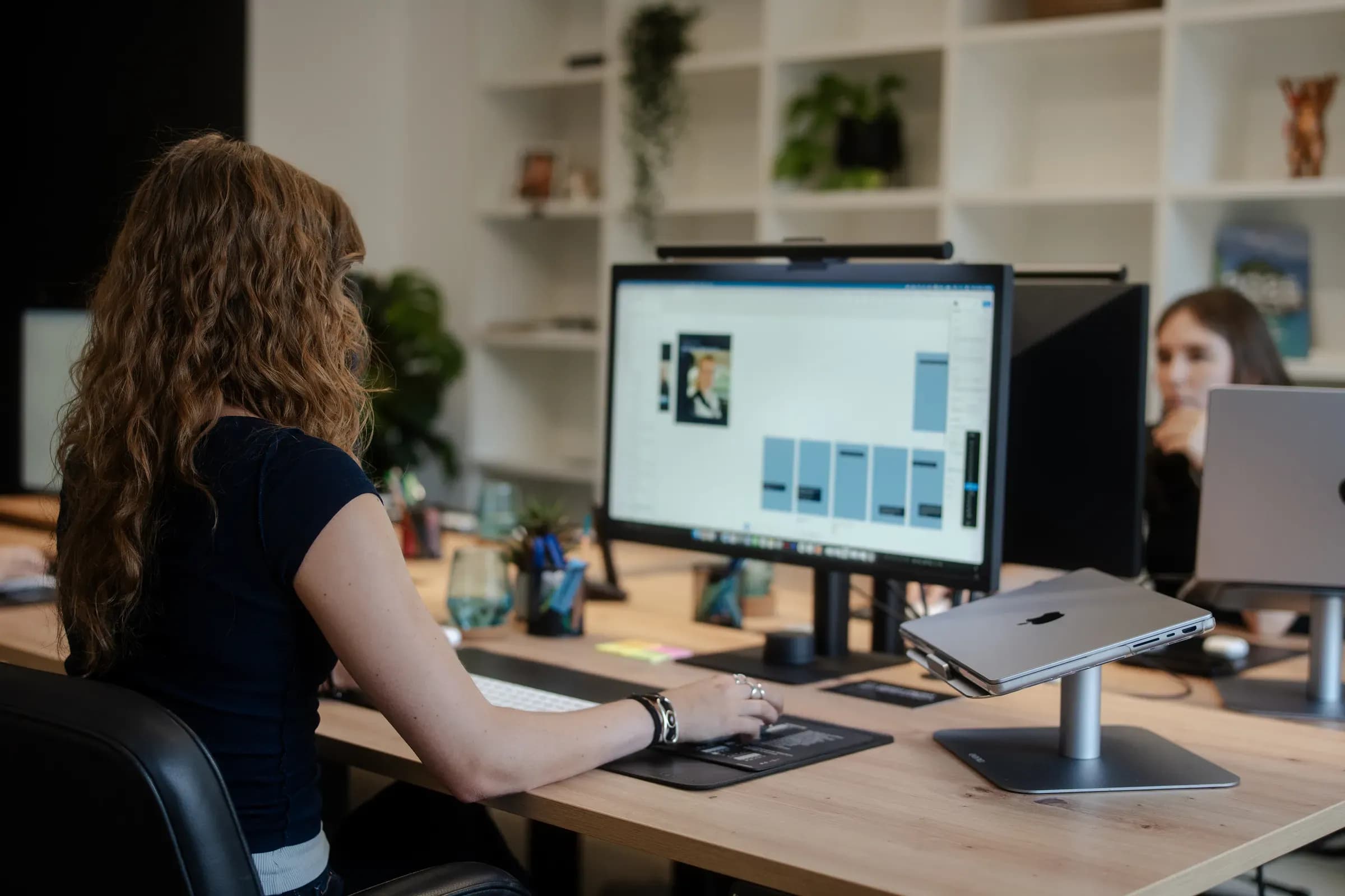 Blick über die Schulter auf einen Monitor mit Website-Entwurf im Büro von skeon digital